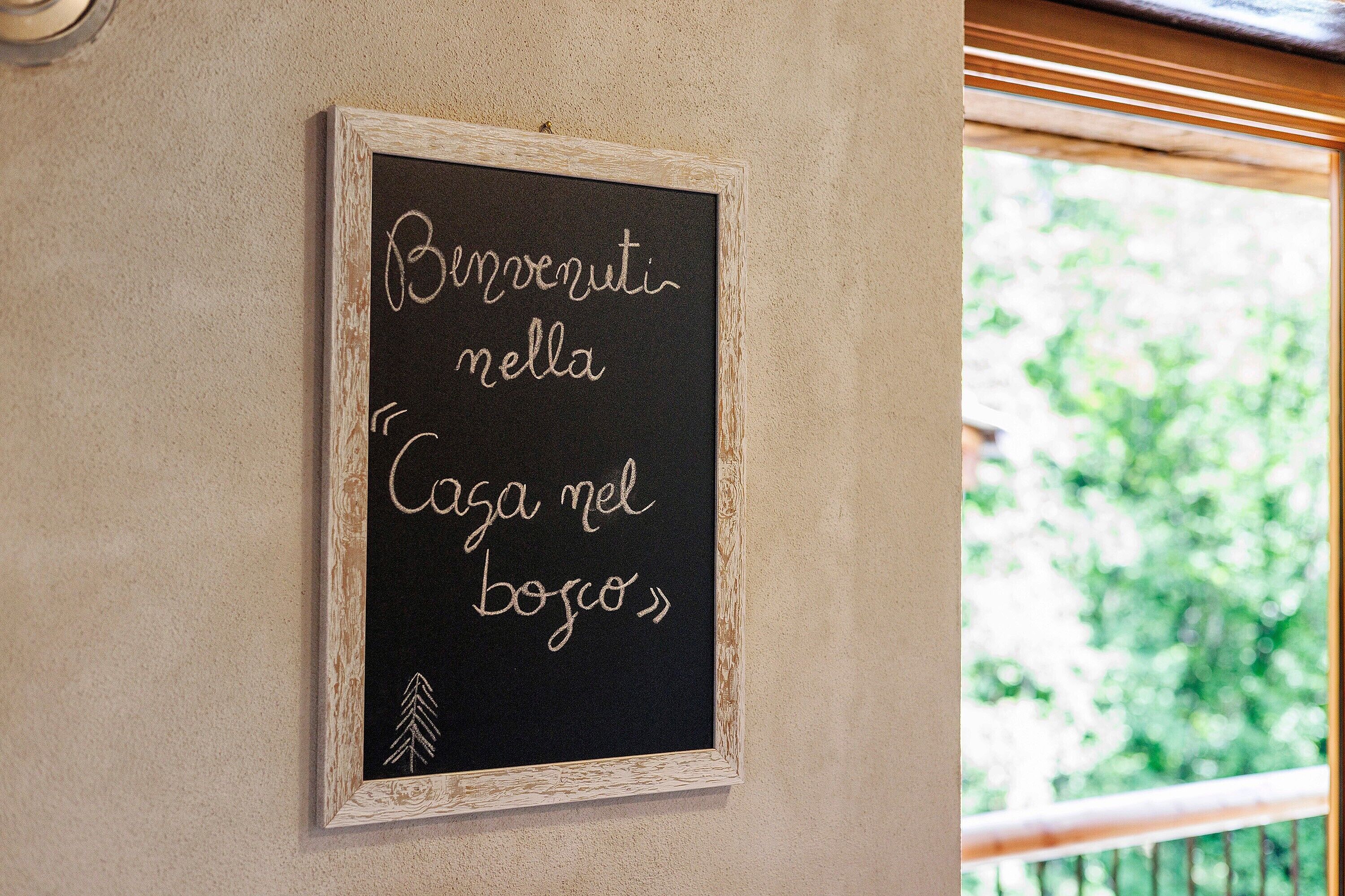 Eine Tafel mit italienischem Text an einer Wand.
