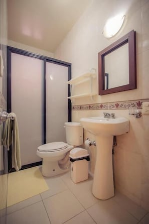 Un baño con inodoro, lavabo y espejo.