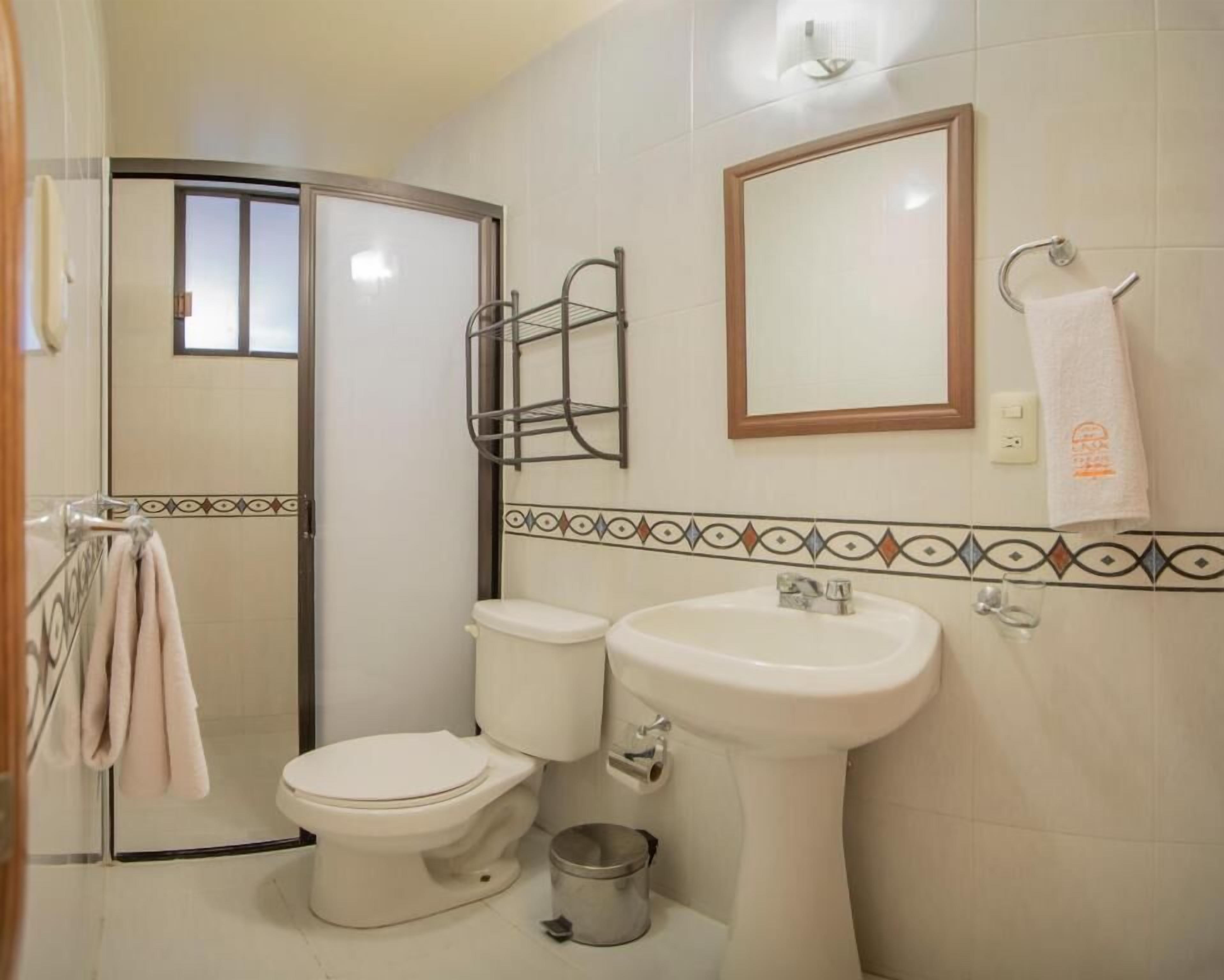 Une salle de bain avec des toilettes, un lavabo et une douche.