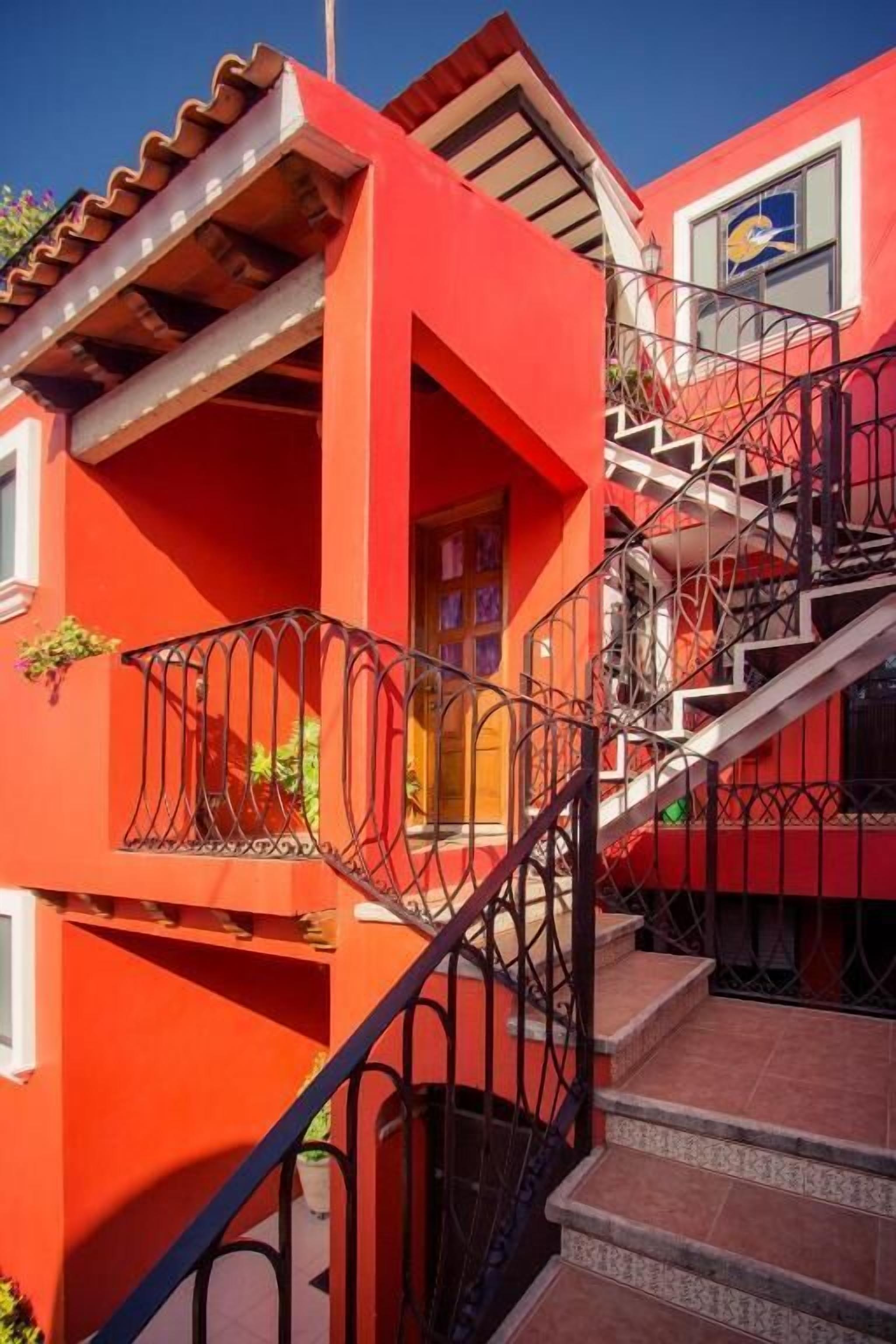 A red building with a staircase and a balcony.