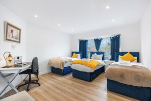 Ein Hotelzimmer mit zwei Betten, einem Schreibtisch und einem Stuhl.