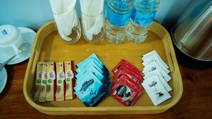 A tray with coffee packets, sugar packets, napkins, and water bottles.