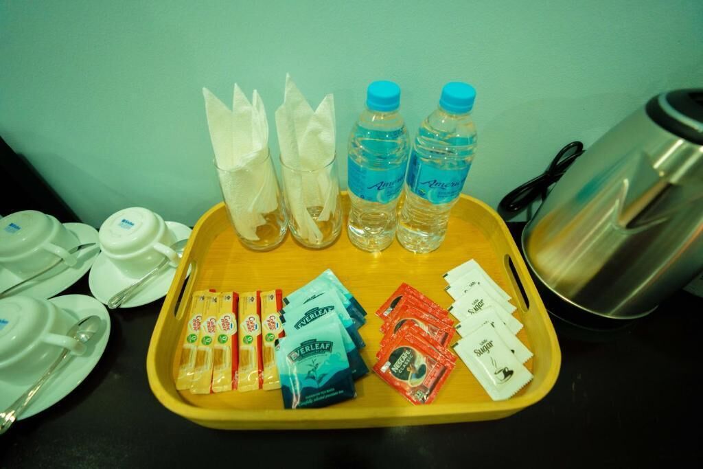 A tray with water bottles, napkins, sugar packets, and coffee packets.