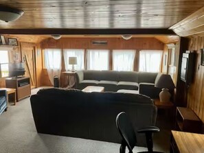 A cabin interior with a sofa, a table, and a television.