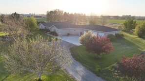 A single-story house with a sloped roof, a front porch, and a driveway leading to the entrance.