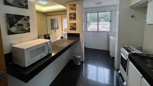 Una cocina moderna con microondas, estufa y ventana con vistas.