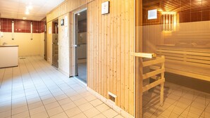 A sauna room with wooden walls and a bench, a tiled floor, and a visible door leading to a bathroom. - Cosy Alpine Studio for Romantic Getaway (Gresse-en-Vercors)