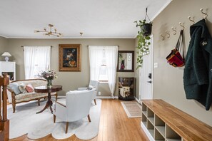 Ein Wohnzimmer mit einer Couch, einem Sessel, einem runden Tisch und einer Bank.