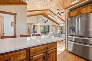 A spacious kitchen with a large island, wooden cabinetry, and a stainless steel refrigerator. - 3BR, 3.5Bath + Hot Tub + Private Patio (Galena)