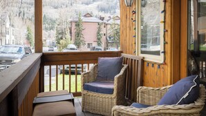 A wooden deck with wicker chairs and a view of a mountain. - Stylish Renovated Telluride 2BR Condo – Walk to Ski, Town, Shops & Restaurants, Sleeps 6 (Telluride)
