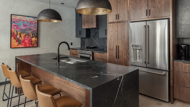 A modern kitchen with a central island, bar stools, stainless steel appliances, and wooden cabinets. - Stylish Renovated Telluride 2BR Condo – Walk to Ski, Town, Shops & Restaurants, Sleeps 6 (Telluride)