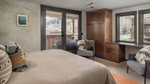 A bedroom with a bed, a desk, a chair, a ceiling fan, and a window. - Stylish Renovated Telluride 2BR Condo – Walk to Ski, Town, Shops & Restaurants, Sleeps 6 (Telluride)