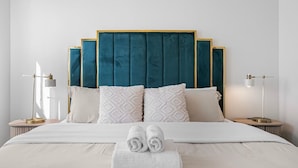 A hotel room with a large bed, two bedside tables, and a headboard. - Spacious 7-BR Home in Hayward with A/C &Parking (Hayward)