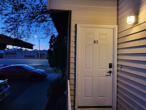 Una puerta blanca con la etiqueta 'A1', un buzón y un accesorio de iluminación a la derecha.
