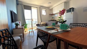 A modern kitchen with a dining table, chairs, and a view of the city. - Downtown Rio • VLT at the Door • Pool • Wi-Fi • 20 min Copacabana. (Rio de Janeiro)