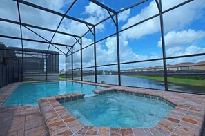 Ein Pool mit Blick auf einen See und entfernte Gebäude.