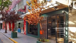 Un edificio con escaparate, ventanas amplias y un árbol en la parte frontal.