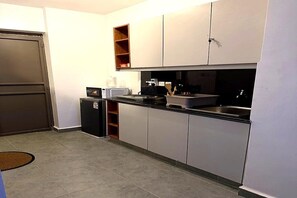 Eine kleine Küche mit Mikrowelle, Toaster und Spüle.