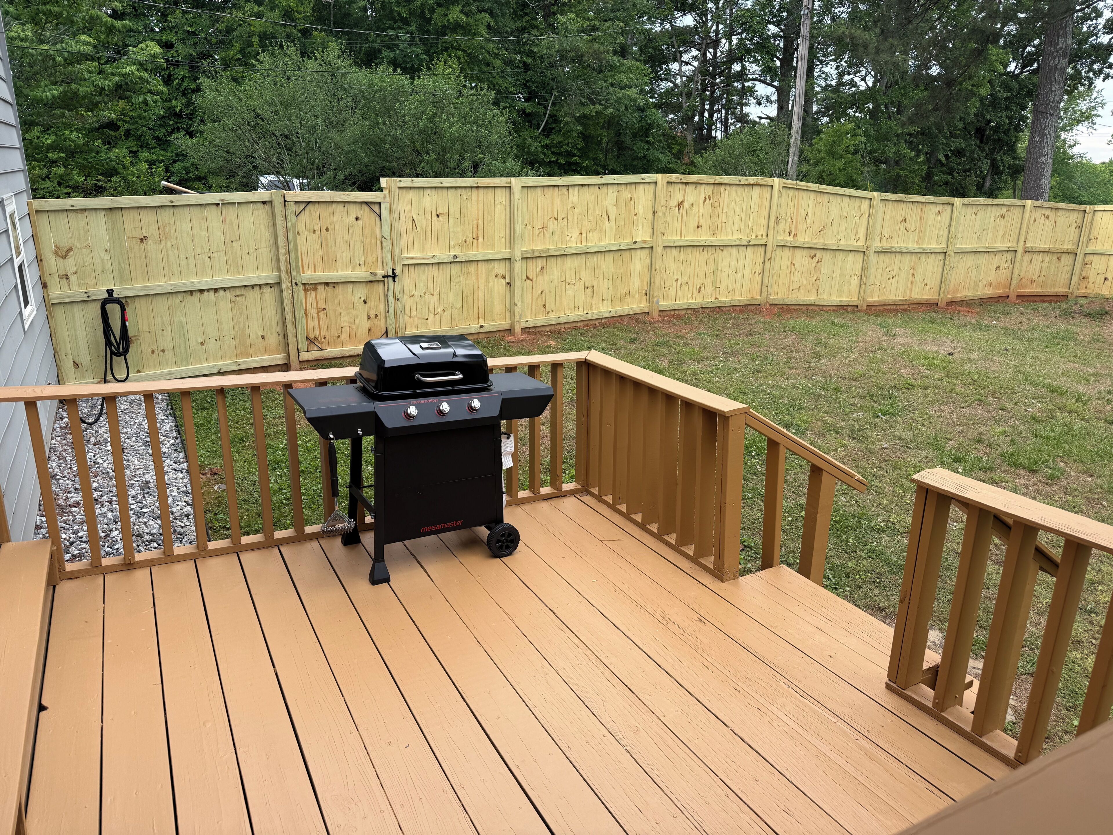 A wooden deck with a barbecue grill.