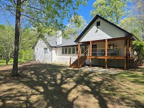 A two-story house with a covered porch and a staircase leading to the upper level.
