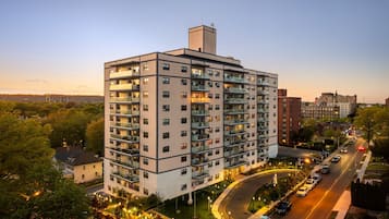 Ein mehrstöckiges Hotel mit Balkonen, einem Parkplatz und Blick auf die umliegende Stadtlandschaft.