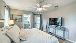 A bedroom with a bed, a ceiling fan, a TV, and a dresser. - Stylish Coastal  Cottage Near Downtown Punta Gorda (Punta Gorda)