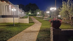 A pathway leading to a building with a staircase and a large potted plant. - Relais Villa Caia (Noto)