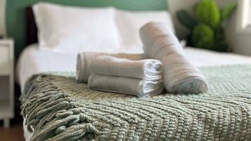 Escritorio, tabla de planchar con plancha, wifi y ropa de cama