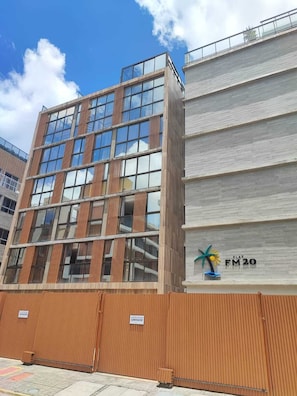 Un edificio moderno con ventanas amplias, un cerco de madera y un letrero que indica un garaje.