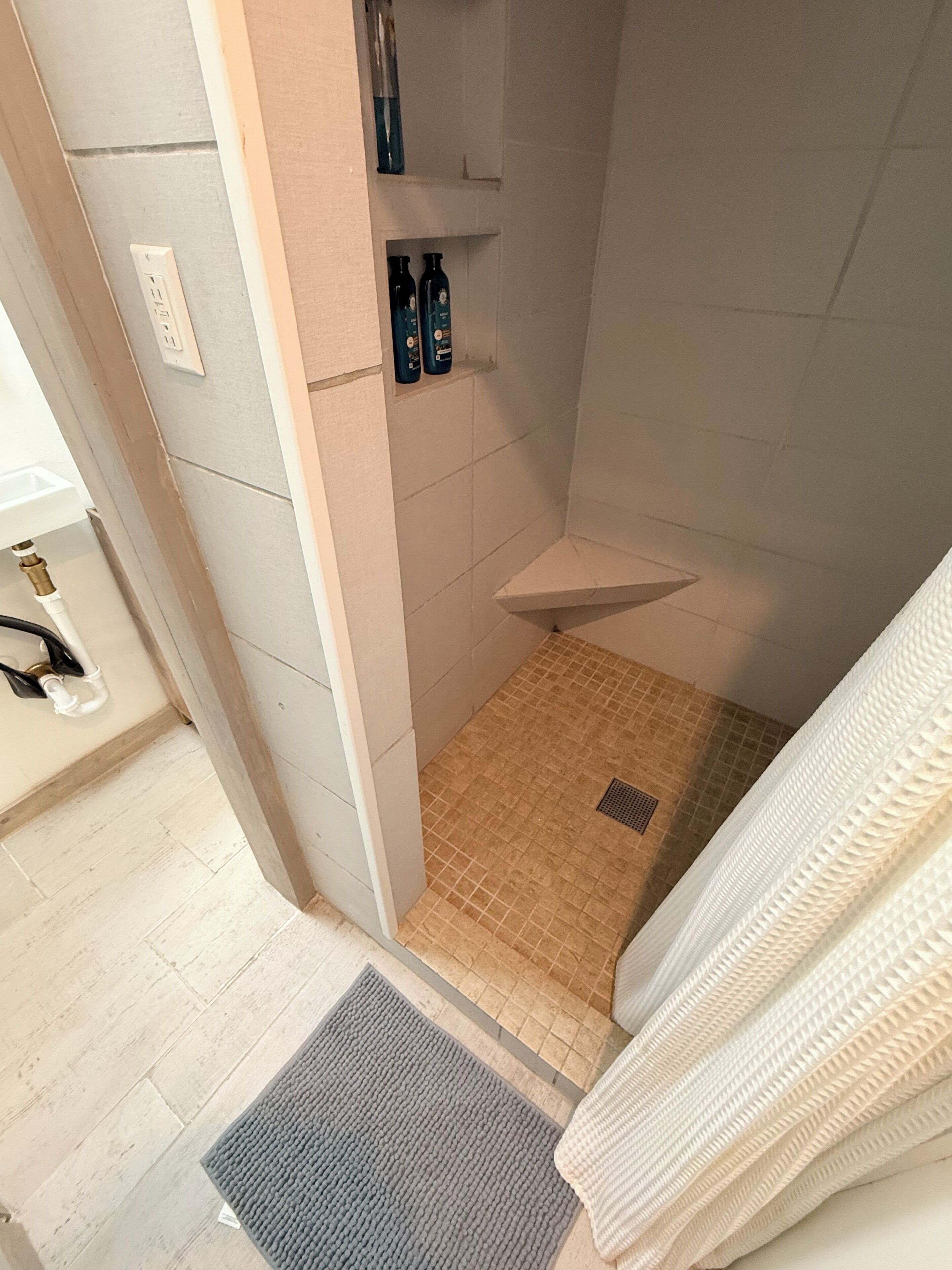 Een badkamer met een douche, toilet en wastafel.