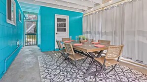 Un comedor con una mesa de madera, sillas y un tapete estampado.