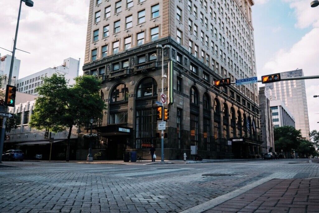 A historic building with large windows and a corner entrance, located at a city intersection.