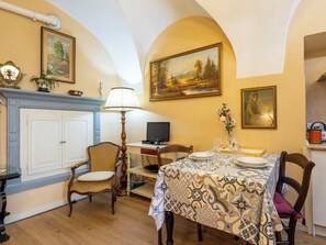 A dining area with a table set for two, a television, and a fireplace. - La Quiete by Interhome (Verbania)