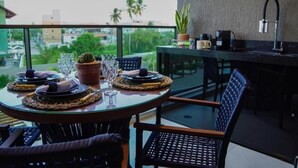 Zona pranzo con un tavolo rotondo apparecchiato per quattro persone, con piatti, bicchieri e un cactus come elemento decorativo.