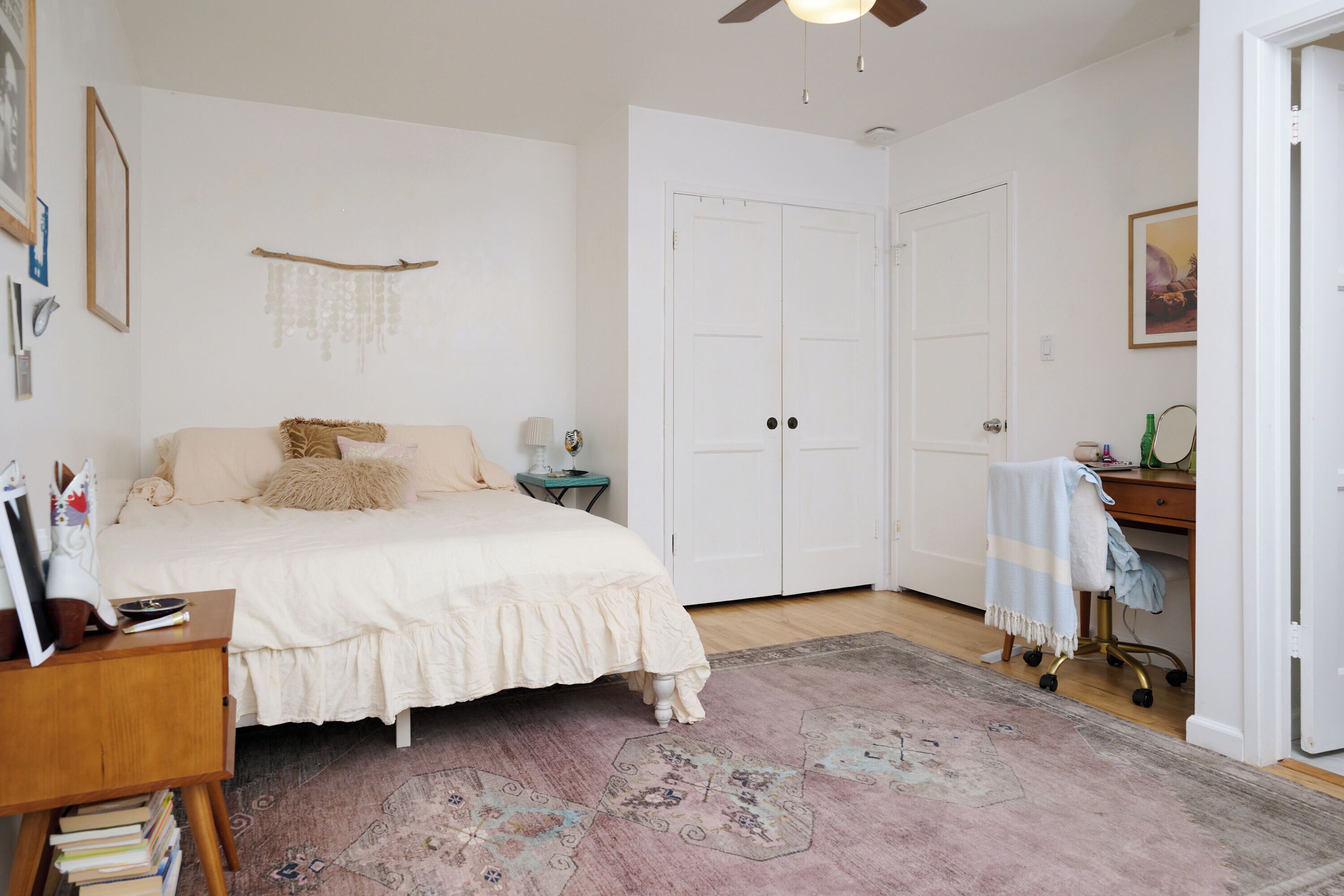Un dormitorio con cama, mesitas de noche, escritorio, silla y armario.