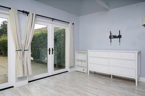 Una habitació amb una porta corredissa de vidre, un taulell blanc i una prestatgeria penjada a la paret.