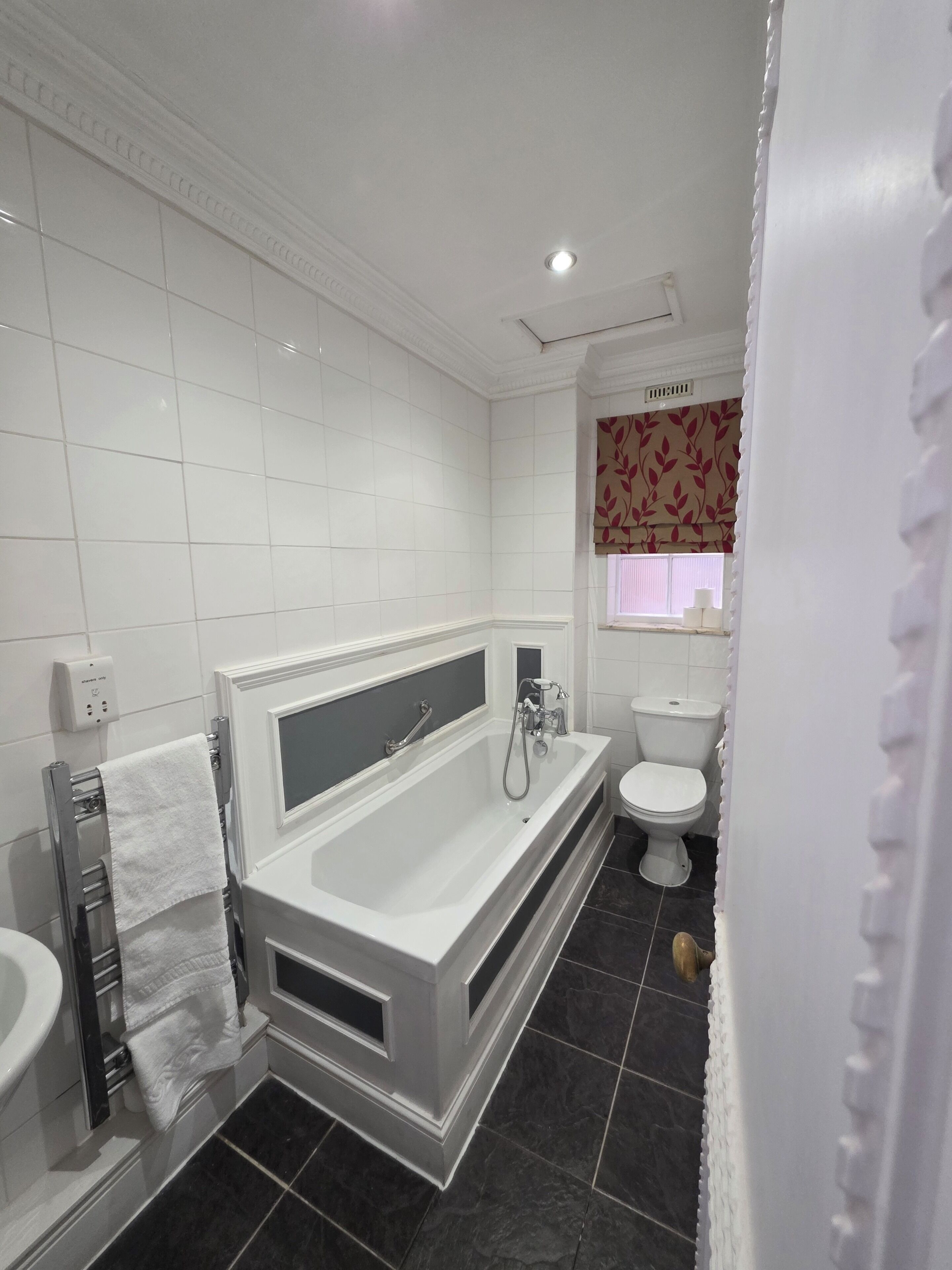 A modern bathroom with a bathtub, toilet, and vanity.