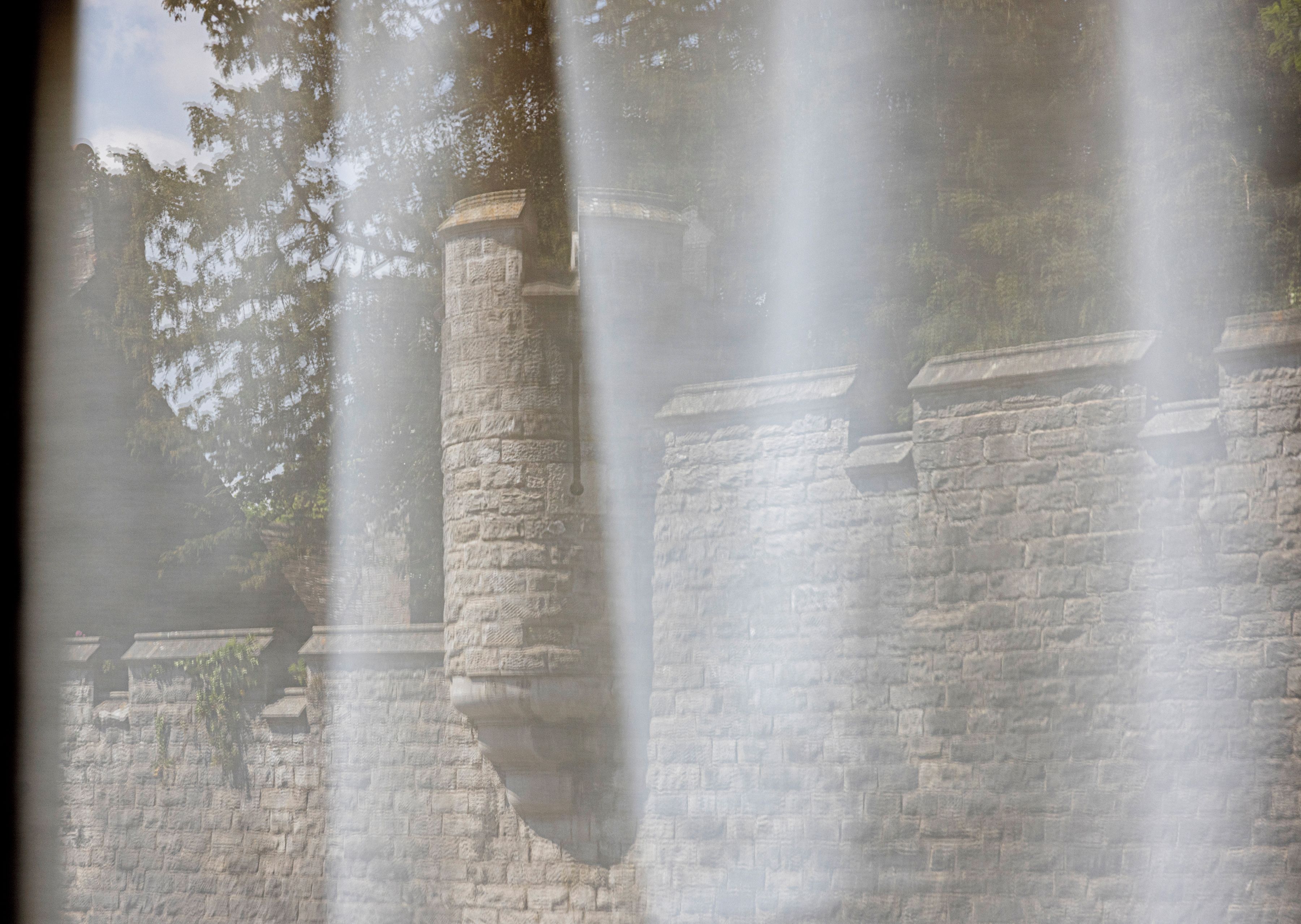 A stone wall with a water feature in front of it.