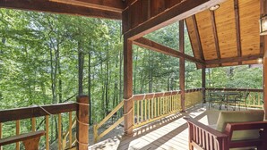 A wooden deck with a railing, a table, and a chair. - Quiet Retreat for Couples, Wi-Fi, Coz,y, Great Location (Rogers)