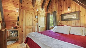 A wooden cabin bedroom with a bed, a small table, and a window. - Quiet Retreat for Couples, Wi-Fi, Coz,y, Great Location (Rogers)