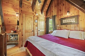 A wooden cabin bedroom with a bed, a small table, and a window. - Quiet Retreat for Couples, Wi-Fi, Coz,y, Great Location (Rogers)