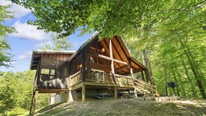 A wooden cabin with a balcony, surrounded by trees. - Quiet Retreat for Couples, Wi-Fi, Coz,y, Great Location (Rogers)