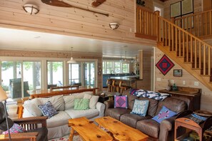 Ein geräumiger Wohnbereich mit Sofa, Couchtisch und einer Holztreppe.