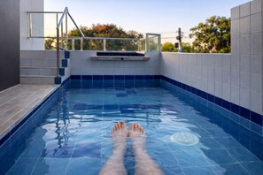 Une piscine aux murs recouverts de carreaux, offrant une vue dégagée sur le ciel.