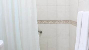A bathroom with a shower, toilet, and a towel rack.