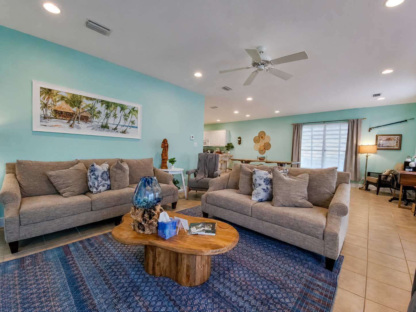 A living room with two sofas, a coffee table, and a ceiling fan.