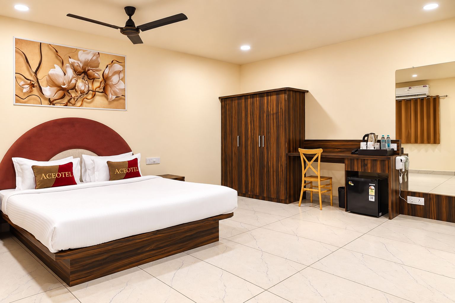 Una habitación de hotel con cama, escritorio, armario y espejo.