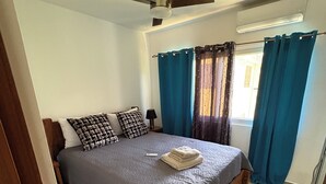 A bedroom with a bed, curtains, a ceiling fan, and a window with curtains. - Delightful 1-bedroom apartment with AC in Sosua (Sosua)