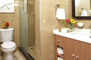 Ein Badezimmer mit Toilette, Dusche, Waschbecken und Spiegel.