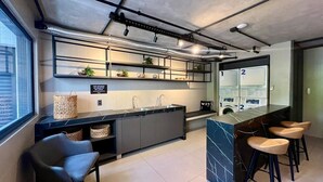 Cozinha moderna com ilha de mármore, banquetas e uma pia embutida.
